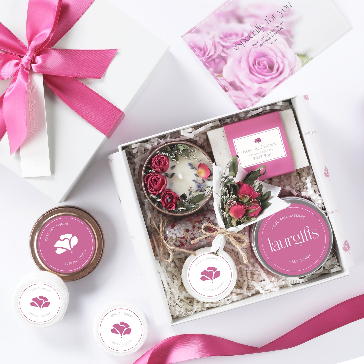 Gift set with pink and white theme featuring a candle, soap, and other items in a box.