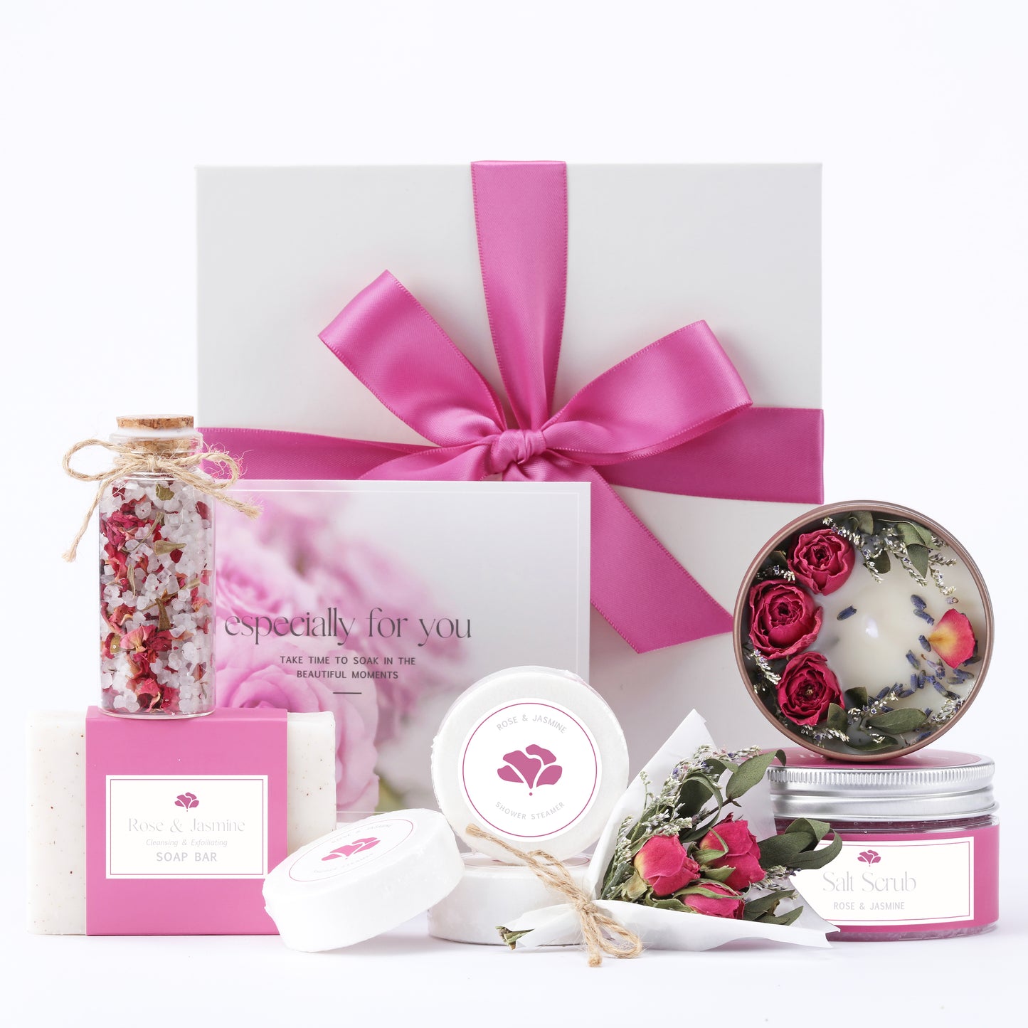 Gifting set with pink ribbon, floral elements, and decorative items on a white background
